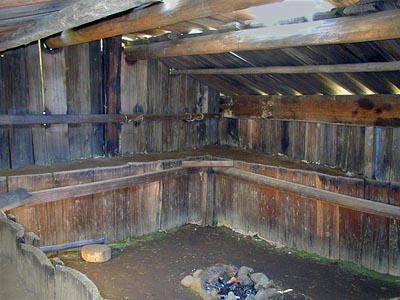[Photo inside plank house]